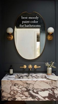 a bathroom vanity with marble counter top and gold faucet, in front of a round mirror that says best mood paint color for bathrooms