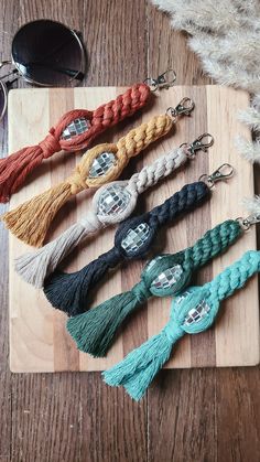 six different colored tassels on a wooden board with sunglasses and eyeglasses in the background