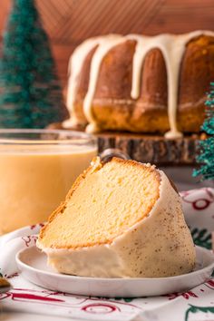 a slice of pound cake on a plate with frosting and christmas trees in the background