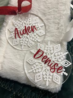 two personalized christmas ornament ornaments on a fur pillow