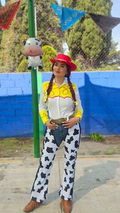 a woman dressed as a cowgirl standing next to a pole