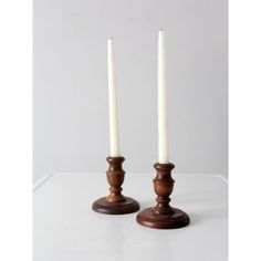 two white candles sitting on top of each other