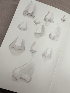 an open book with drawings of feet and noses on it's cover, sitting on a table