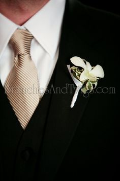 a man in a suit and tie with a boutonniere on his lapel