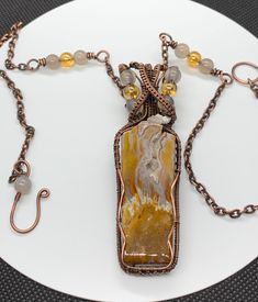 Stunning Plume Agate Necklace in wire wrapped Copper with yellow glass and gray agate bead accents. A bold, statement necklace. Comes on a 19 1/4" bead accented chain. Agate cut and polished by Monkeylion Designs. An original Monkeylion Design. Focal point is approximately 3 1/4" long and 1" wide at the top. This necklace has been antiqued, polished and sealed. Sealed with Protectaclear. ProtectaClear is a clear, protective coating that is tough enough to protect jewelry and is safe for wear aga Agate Large Pendant Necklace In Nature-inspired Style, Nature-inspired Agate Necklace With Large Pendant, Ocean Jasper Wire Wrapped Pendant Necklaces, Wire Wrapped Ocean Jasper Pendant Necklaces, Wire Wrapped Ocean Jasper Pendant Necklace, Artisan Wire Wrapped Pendant Beaded Necklace, Amber Agate Wire Wrapped Necklace, Artisan Jewelry With Ocean Jasper Gemstone Beads, Bohemian Ocean Jasper Necklaces For Gifts