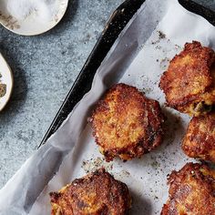 some fried food is sitting on a tray next to other dishes and utensils