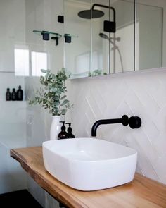 a white bathroom sink sitting on top of a wooden counter