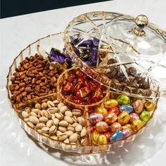 a glass platter filled with assorted candies and nuts