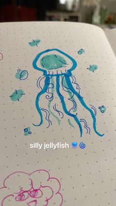 a drawing of a jellyfish on top of a white paper with blue and pink ink