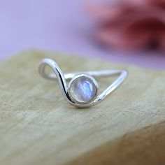 TITLE: -  Wave Ring Rainbow Moonstone Ring For Girls 925 Sterling Silver Handmade Jewelry Round Gemstone Ring   SPECIFICATIONS: - ❖ Metal:  925 Solid sterling silver ❖ Gemstone:  Moonstone  ❖Gemstone Size : 6 mm ❖ Gemstone Shape:  Round ❖ Total Weight:  2.5 Gram ❖ Gemstone Setting: Bezel   Note: Our use of natural stones may result in slight variations in texture and color in the actual product you receive, but the quality and grade of the stone remain consistent. FEATURES: -  * elegant Moonstone Silver Wave Ring, a perfect blend of simplicity and sophistication. Crafted from high-quality sterling silver, this ring features a beautifully polished moonstone that radiates a soft, iridescent glow. Its unique wave design adds a touch of modern elegance, making it an ideal accessory for any occ Rose Stone Ring, Silver Ring Gemstone, Silver Birthstone Ring With Natural Stones For Gift, Adjustable Sterling Silver Moonstone Birthstone Ring, Adjustable Moonstone Open Ring Birthstone, Adjustable Open Moonstone Birthstone Ring, Silver Birthstone Ring With Natural Stones For Promise, Silver Birthstone Ring With Natural Stones For Anniversary, Adjustable Moonstone Promise Ring With Natural Stones