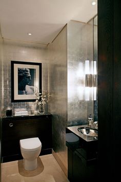 a bathroom with a white toilet sitting next to a bath tub and sink in it