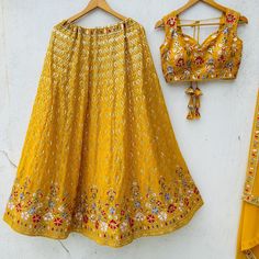 Mustard Yellow Lehenga Choli Set | Ready-to-Wear Georgette Ensemble with Embroidery and Sequin Work Elevate your traditional wardrobe with this stunning mustard yellow lehenga choli set, perfect for any festive occasion or special event. Features: Fabric: Crafted from high-quality georgette, this lehenga choli set combines elegance with comfort. Embroidery & Sequin Work: The blouse is adorned with intricate embroidery and shimmering sari sequin work, adding a touch of glamour and sophistication. Fit: Designed to fit up to a 42-inch bust and a 42-inch waist, ensuring a flattering silhouette for various body types. Skirt Length: The lehenga skirt measures up to 41 inches in length, providing ample coverage and a graceful flow. Un-stitch: When a garment is described as "un-stitched," it means Gold Embroidered Choli For Wedding, Gold Sets With Motifs In Traditional Drape, Yellow Sets With Zari Work For Traditional Ceremonies, Gold Embroidered Fabric For Wedding And Navratri, Fitted Embroidered Fabric With Motifs For Wedding, Wedding Embroidered Fitted Fabric With Motifs, Semi-stitched Yellow Blouse Piece For Wedding, Yellow Embroidered Sets For Traditional Ceremonies, Yellow Sets With Resham Embroidery For Traditional Ceremonies