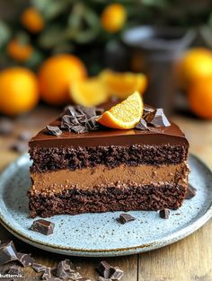 a slice of chocolate cake with oranges in the background