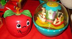 there are two toys on the table and one is in an apple shaped container with faces