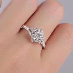 a woman's hand with a diamond ring on top of her finger and the bottom half