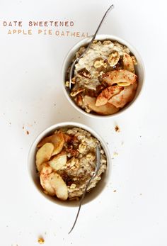 two white bowls filled with oatmeal and apples