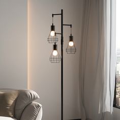 three light floor lamp with caged lamps on each pole in front of a window