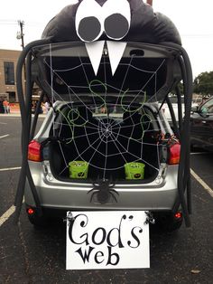 the back end of a car that has been decorated with spider webs and eyes