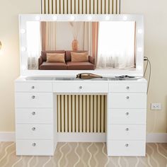 a white vanity with lights on it and a couch in the mirror behind it,