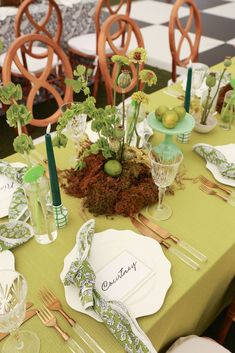 the table is set with green and white place settings