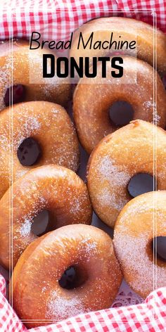 a basket filled with donuts covered in icing and powdered sugar on top of a checkered table cloth