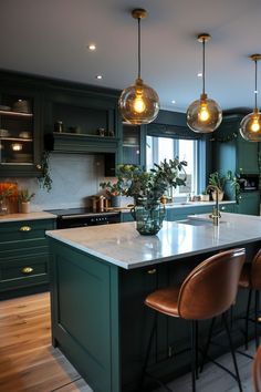 a large kitchen with green cabinets and marble counter tops, hanging lights over the island