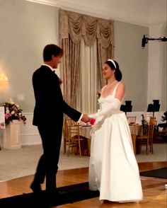 the bride and groom are holding hands at their wedding reception in an elegant room with chandeliers