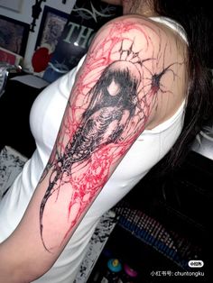 a woman's arm covered in red ink with a black and white bird on it