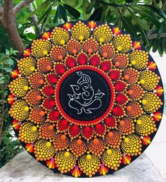 a decorative plate with an image of a ganeshi in the center on a rock