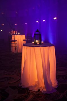 the table is covered with white cloth and lit candles