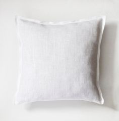 a white pillow sitting on top of a white wall