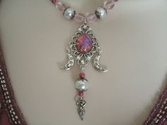 "This beautiful necklace has pink glass beads, glass pearl beads, seed beads, pewter silver accent beads, silver plated bead caps, pewter silver crescent moons, pewter silver goddess and silver plated filigree pendant with pink glass opal setting and rhinestones. 18\" long. Silver plated toggle clasp." Jewelry Witchcraft, Pink Goddess, Necklace Magic, Silver Goddess, Pagan Clothing, Wicca Jewelry, Pagan Necklace, Wiccan Necklace, Goddess Jewelry