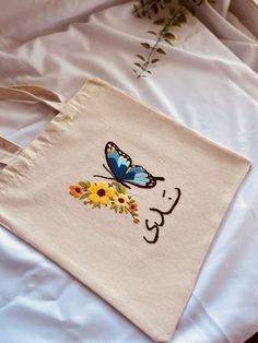 a white bag with a blue butterfly and sunflowers on it