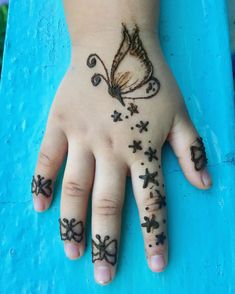 a child's hand with hendi tattoos on it and butterflies drawn on the palm