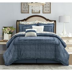 a bed with blue comforter and pillows in a bedroom