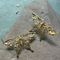 Add a touch of elegance to your outfit with these stunning gold butterfly earrings. Crafted with intricate details, these earrings are perfect for both casual and formal occasions. The butterflies delicately hang from your ears, creating a unique and eye-catching design that will surely make a statement. Upgrade your jewelry collection with these beautiful earrings today. Part of a 3 piece set. Gold Butterfly Charm Earrings For Party, Party Earrings With Gold Butterfly Charm, Gold Earrings With Butterfly Charm For Party, Elegant Gold Butterfly Earrings, Elegant Gold Butterfly-shaped Earrings, Elegant Gold Earrings With Butterfly Charm, Gold Butterfly Earrings For Wedding, Gold Butterfly Earrings For Formal Occasions, Gold Earrings With Butterfly Charm For Formal Events