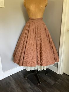 "1950's Vintage Quilted Circle Skirt in great condition. Unlined, metal zipper at back with two buttons.  Front waistband curves into a downwards point, very flattering. Small hole at inside waistband and broken thread ( see pictures for detail). Looks amazing over a crinoline. Size Vintage 13.  Very small waist. Measurements: Waist - 24\" Hip - Free Length from top of back waist band - 27\""