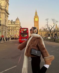 a woman walking down the street in london with big ben in the backgroud