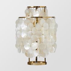 a light fixture with white glass balls hanging from it's centerpiece, against a gray background