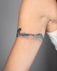 a woman's arm with a blue wave tattoo on the left side of her arm