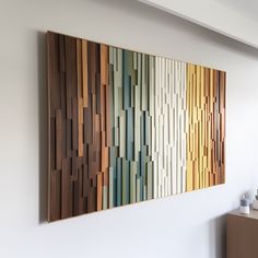 a wooden wall hanging on the side of a white wall