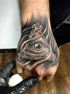 a man's hand with an all seeing eye tattoo on it