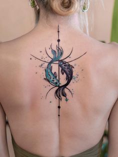 the back of a woman's neck with an abstract tattoo design on her left shoulder