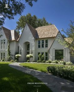 a large white house sitting on top of a lush green field