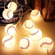 lighted baseball ball string lights on a table next to books and a book bag in the background