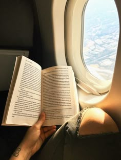 a person is reading a book on an airplane