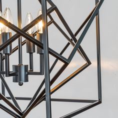 a metal chandelier with five lights hanging from it's center and four sides