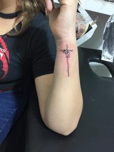 a woman with a cross tattoo on her arm