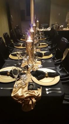 the table is set with black and gold place settings