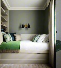 a bed sitting in the middle of a bedroom next to a book shelf